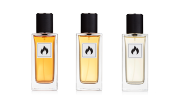 Three rectangular glass perfume bottles with black caps and flame warning labels, filled with amber and clear liquids, arranged side by side on a white background.